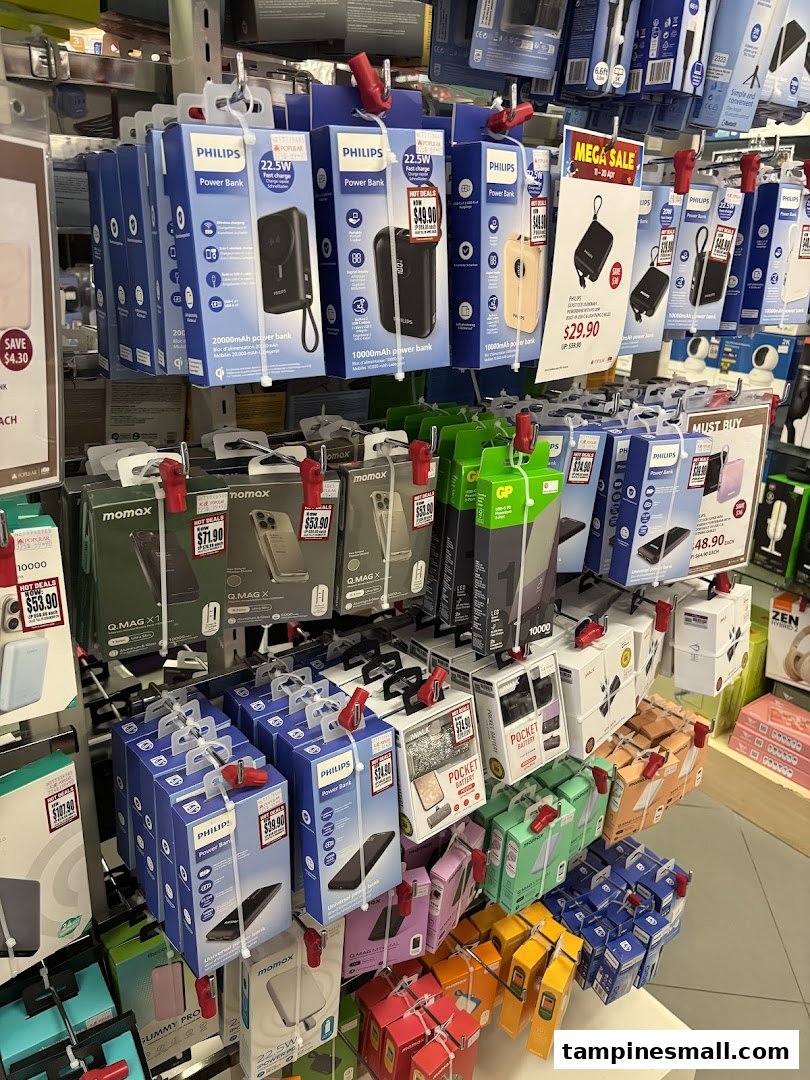 A retail display showcasing various power banks and mobile accessories, including Philips and Momax brands.