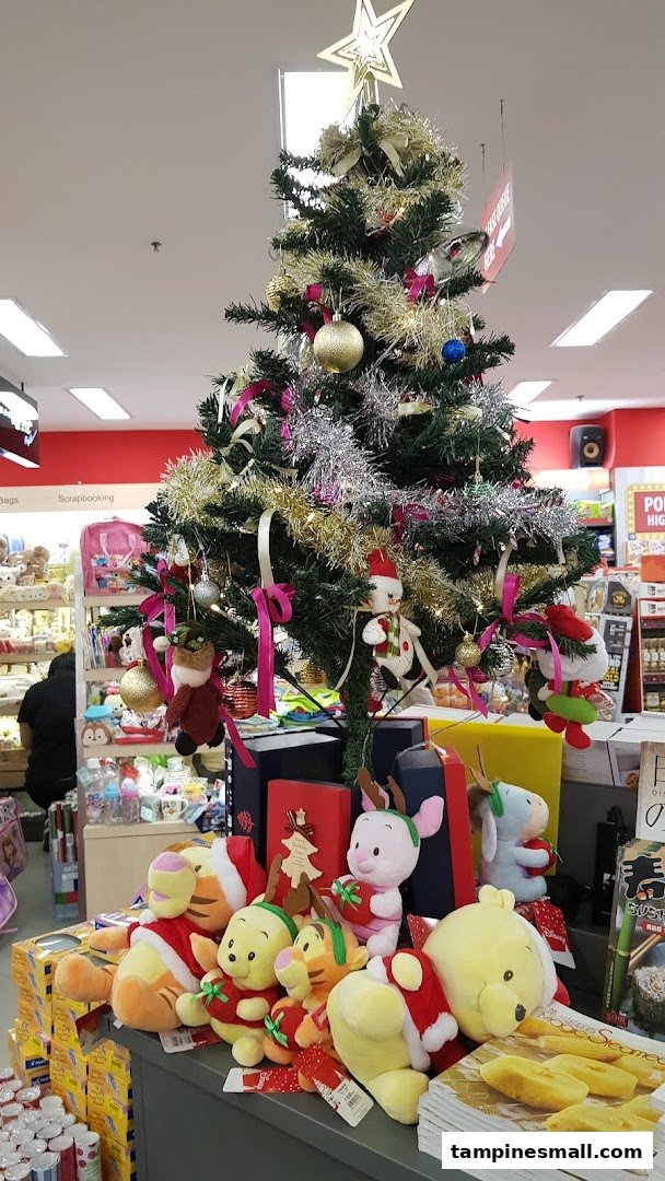 A festive Christmas tree display with Winnie the Pooh plush toys inside a bookstore.