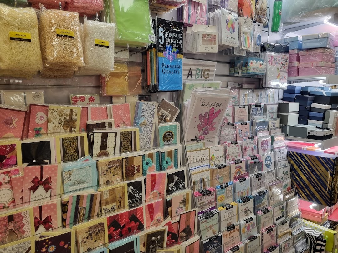 A vibrant display of greeting cards, gift wrap, and party supplies in a retail store.