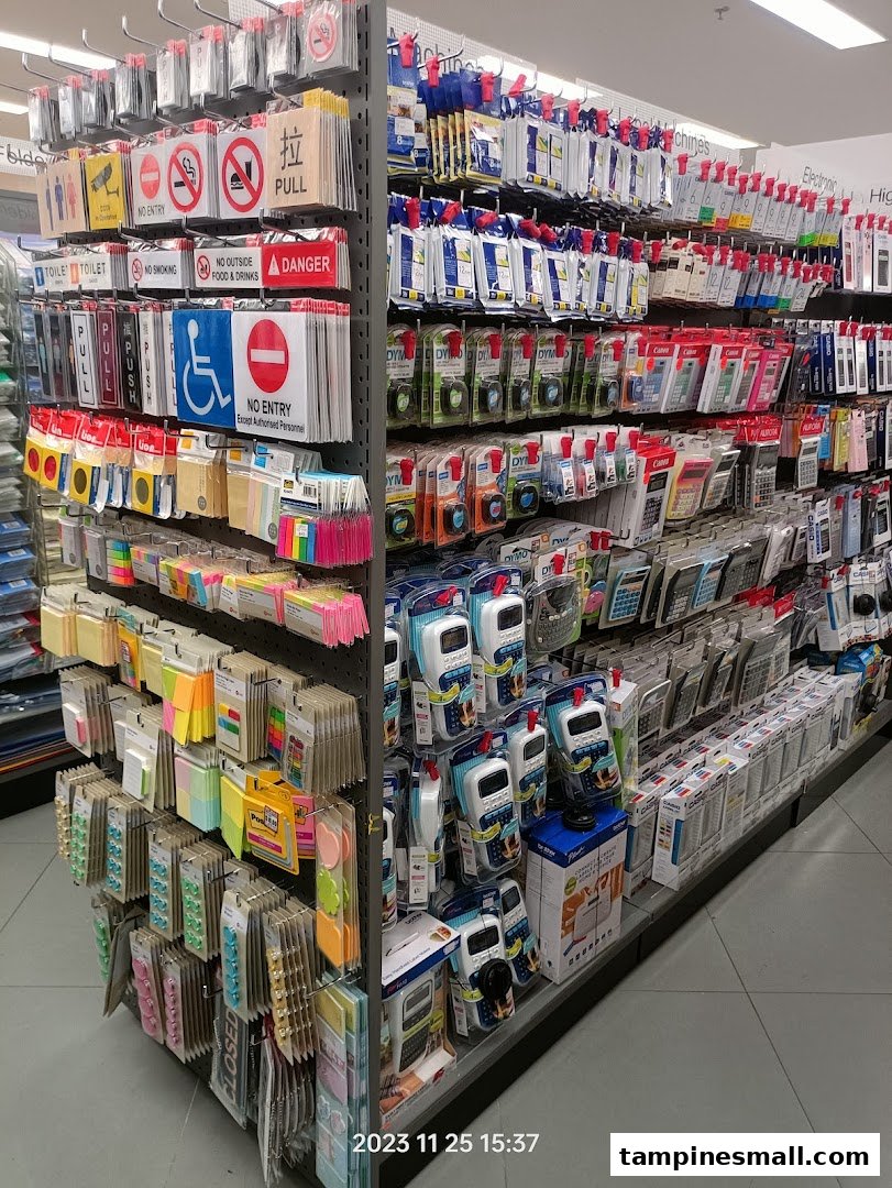An aisle in POPULAR Bookstore displaying a wide range of stationery, signs, calculators, and office supplies.