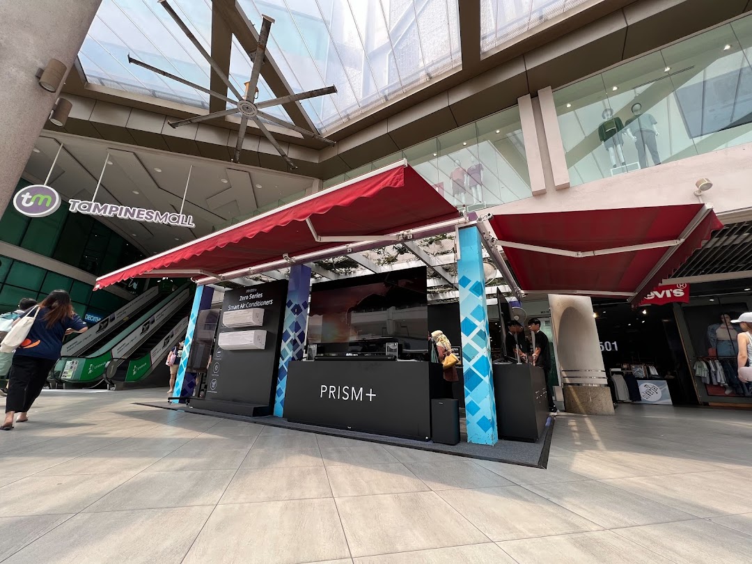 A PRISM+ promotional booth showcasing smart air conditioners and electronics within Tampines Mall.