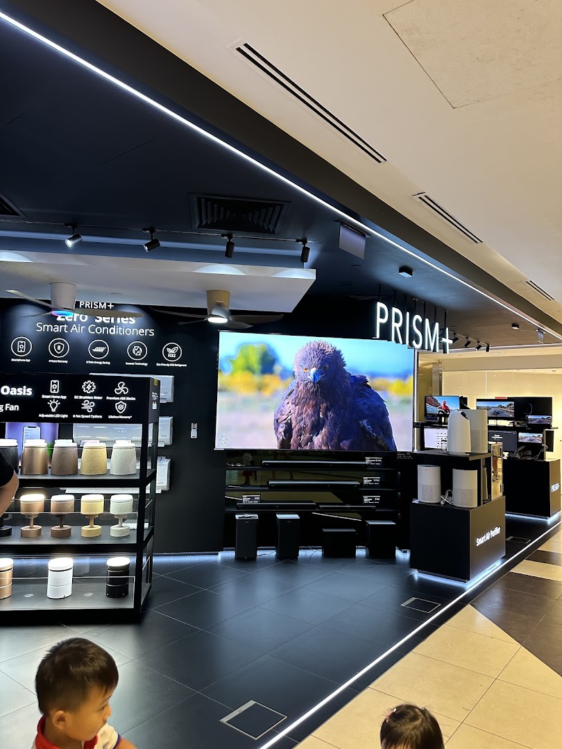 Interior view of PRISM+ store showcasing smart air conditioners, large screen TVs, and air purifiers.