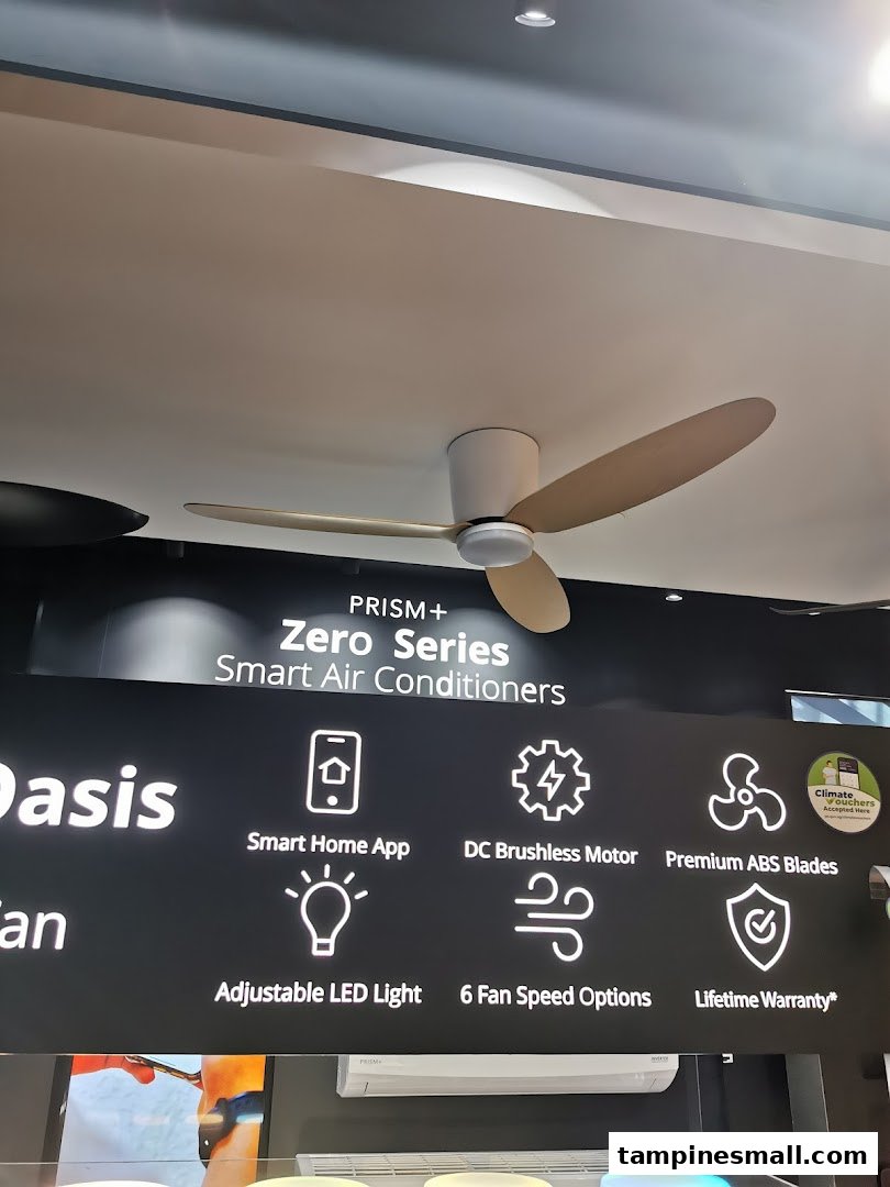 A modern ceiling fan displayed above a sign detailing features of PRISM+ Zero Series Smart Air Conditioners.