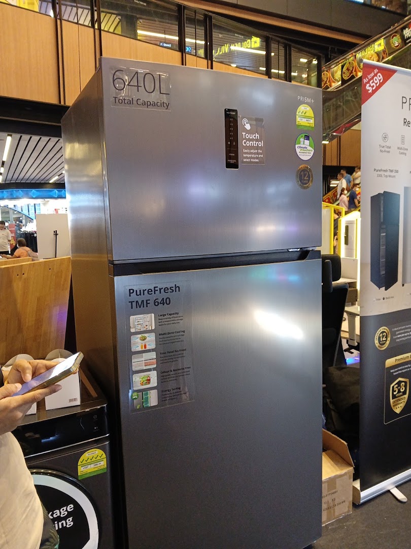 A large silver refrigerator with '640L Total Capacity' and 'Touch Control' displayed in a retail store.