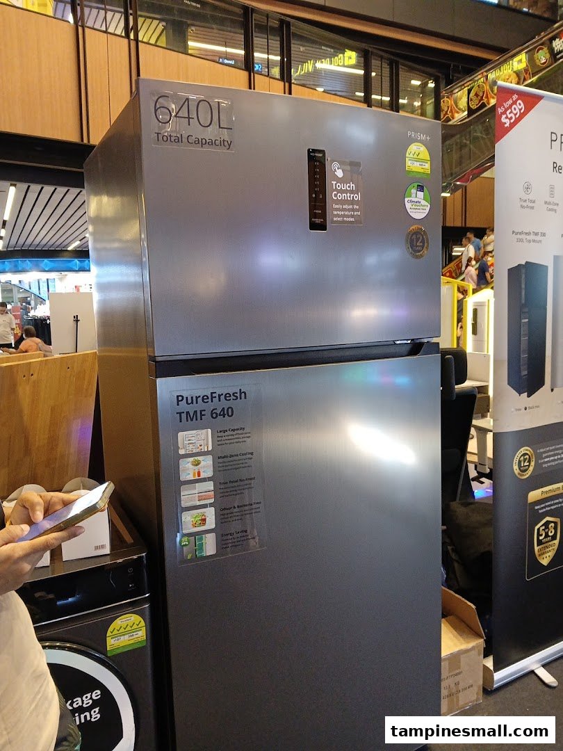 A large silver refrigerator with '640L Total Capacity' and 'Touch Control' displayed in a retail store.