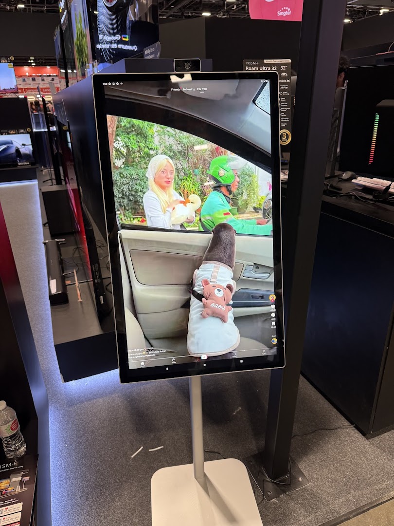 A large vertical display screen showcasing a video, likely a product from PRISM+, in a retail setting.