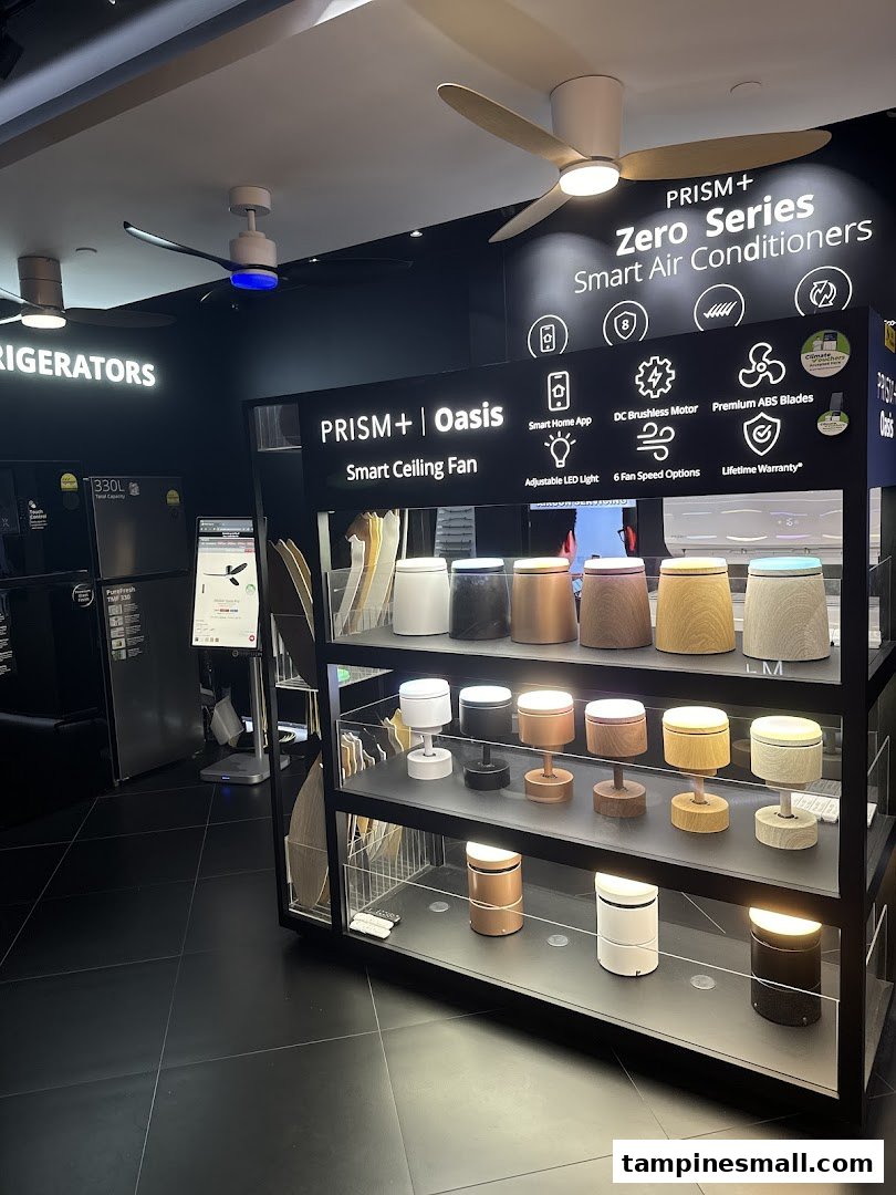 Interior display of PRISM+ smart ceiling fans, air conditioners, and refrigerators in a modern showroom.