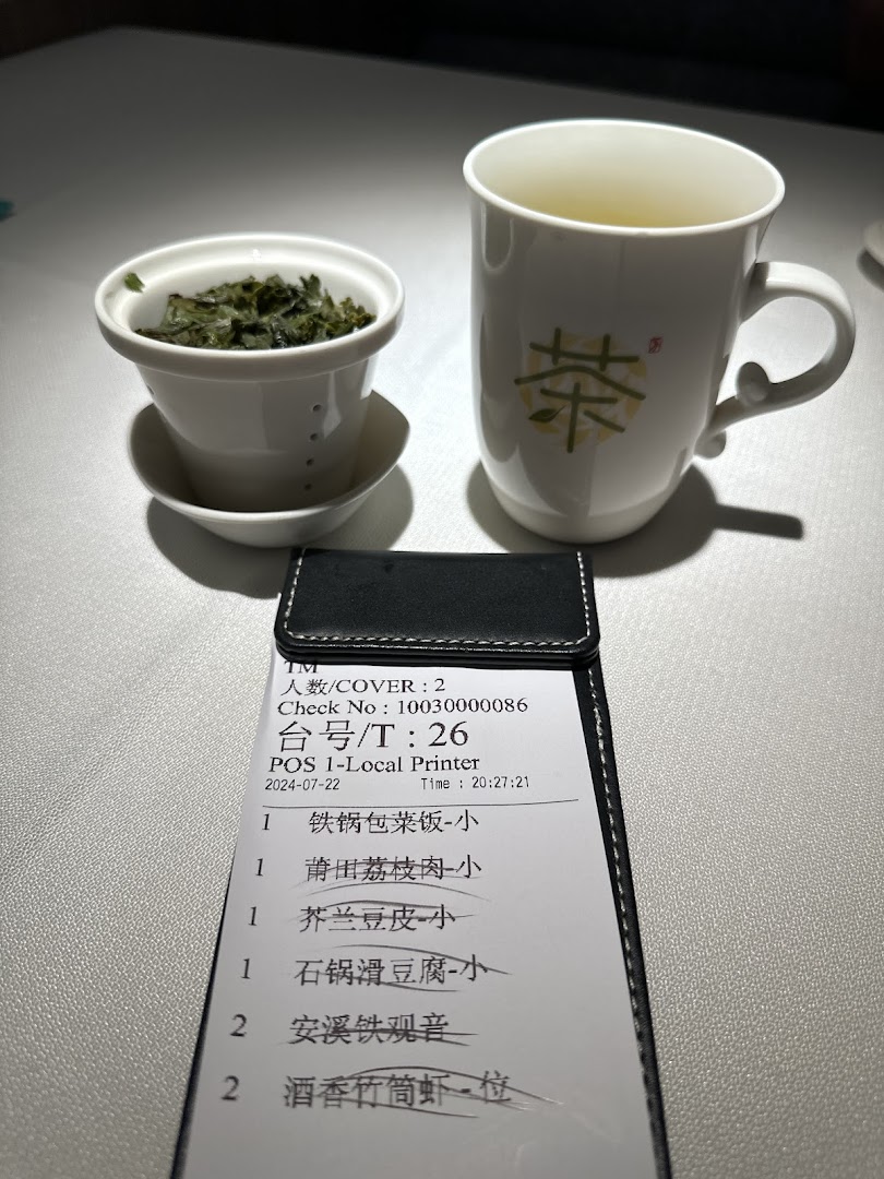 A close-up of a dining table with a tea set and an order slip showing various food and drink items.