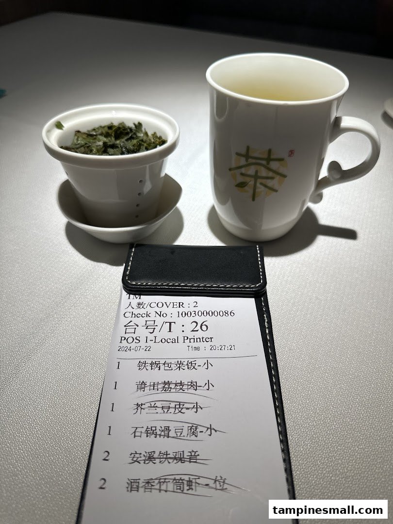 A close-up of a dining table with a tea set and an order slip showing various food and drink items.