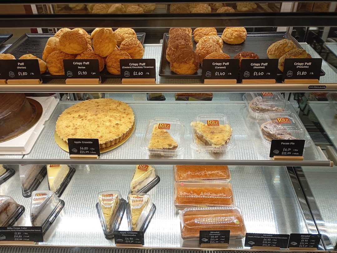 A vibrant display case showcasing a variety of freshly baked pastries, strudels, and pies at Ritz Apple Strudel.