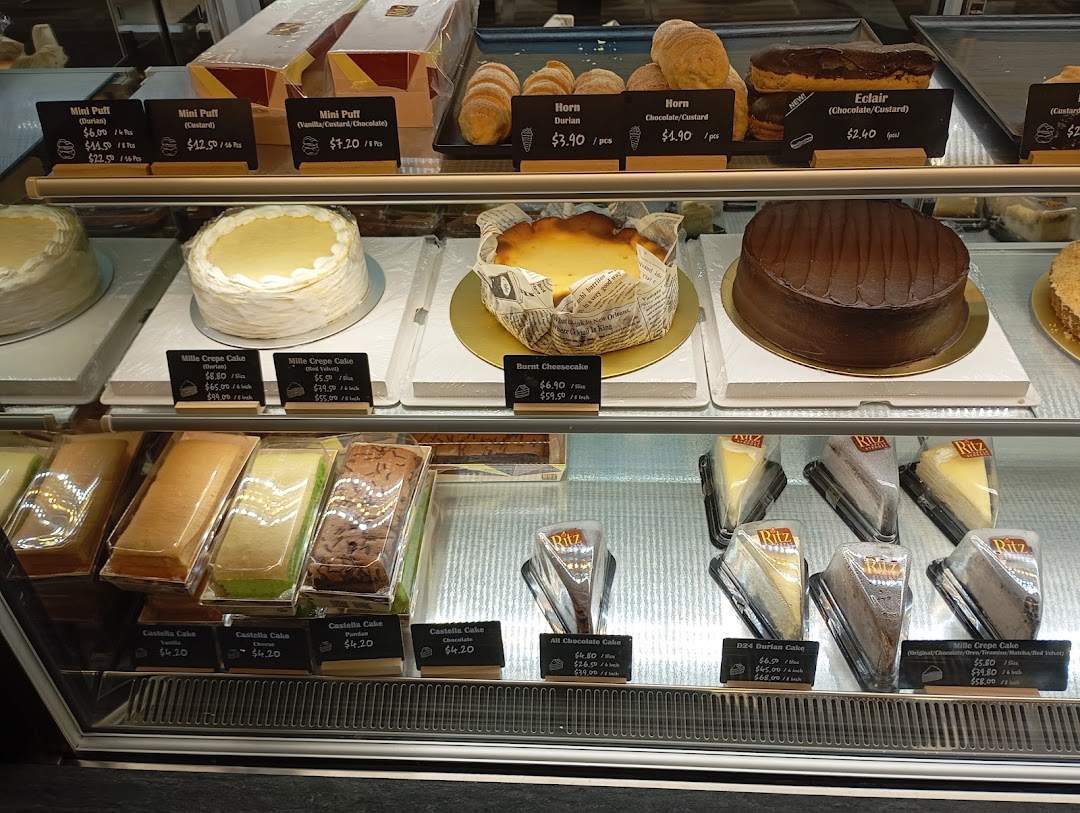 A vibrant display case showcasing a variety of delicious cakes, pastries, and puffs.