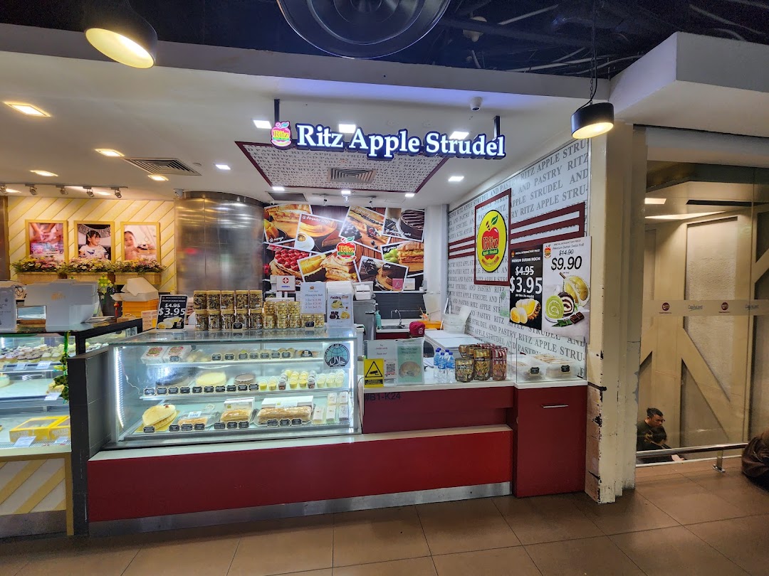 A vibrant shop front of Ritz Apple Strudel, showcasing display cases filled with delicious pastries and desserts.