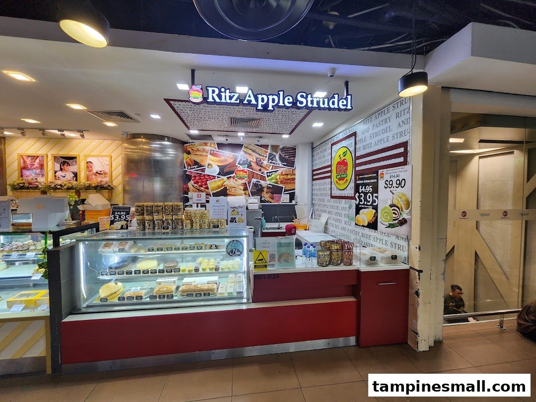 A vibrant shop front of Ritz Apple Strudel, showcasing display cases filled with delicious pastries and desserts.