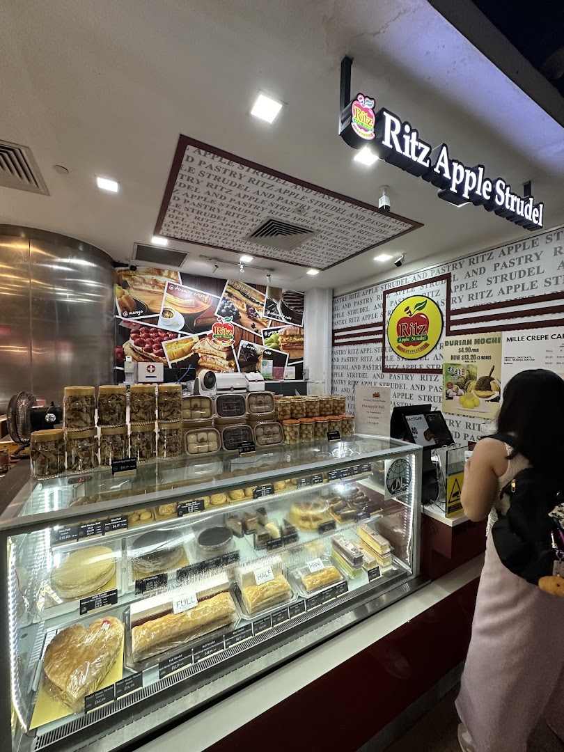An inviting interior view of Ritz Apple Strudel, showcasing a wide array of fresh pastries and desserts in display cases.