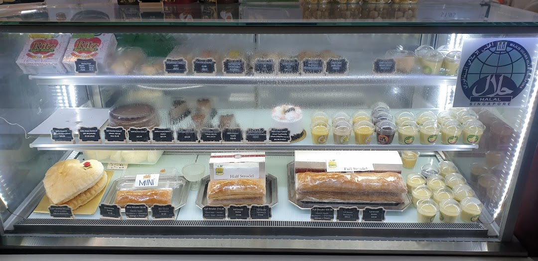 A display case showcasing various pastries, cakes, and desserts at Ritz Apple Strudel.