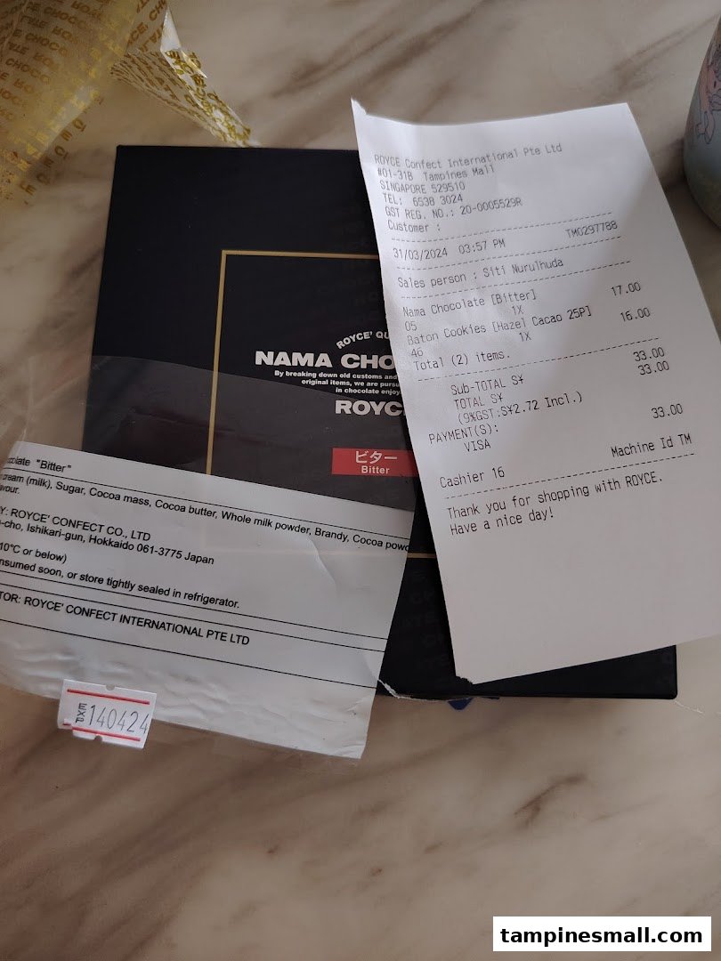 A black box of Royce' Nama Chocolate 'Bitter' with a purchase receipt showing chocolate and cookies.