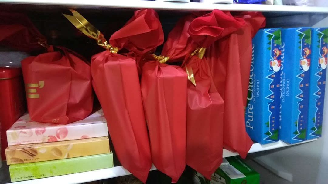 A shelf displaying red gift-wrapped chocolates and blue Christmas-themed Pure Chocolate boxes from Royce.