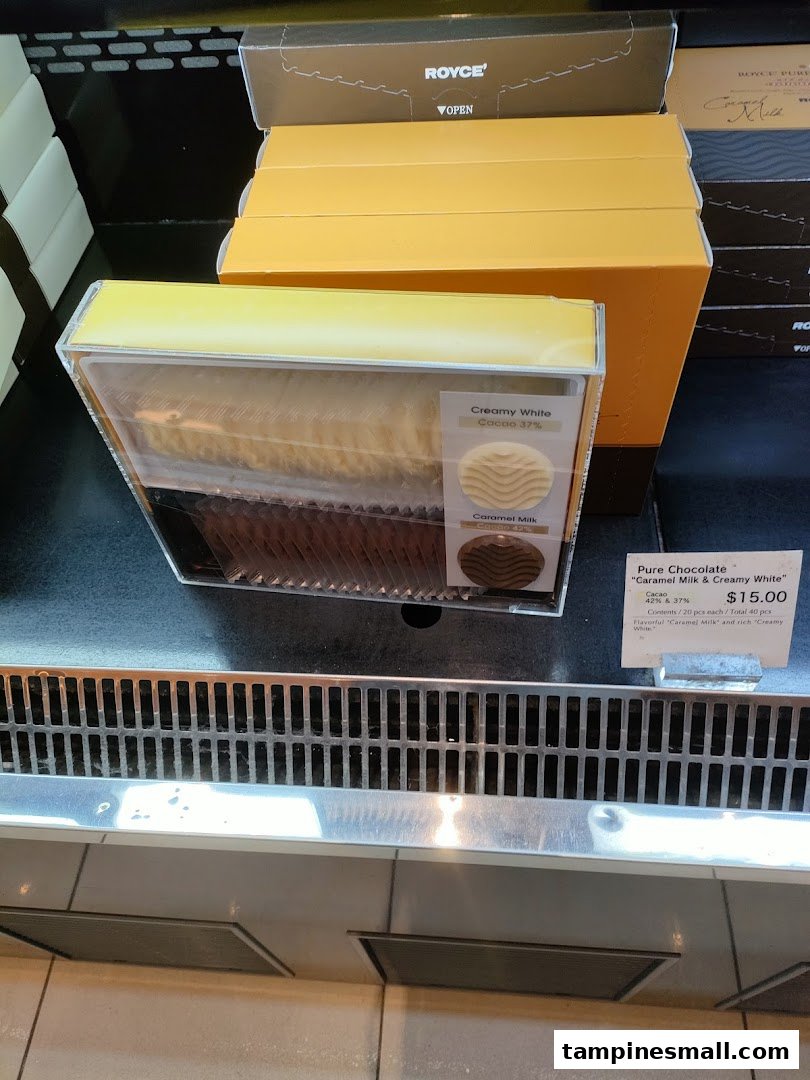 A display of Royce's Pure Chocolate, featuring Caramel Milk and Creamy White varieties with pricing.