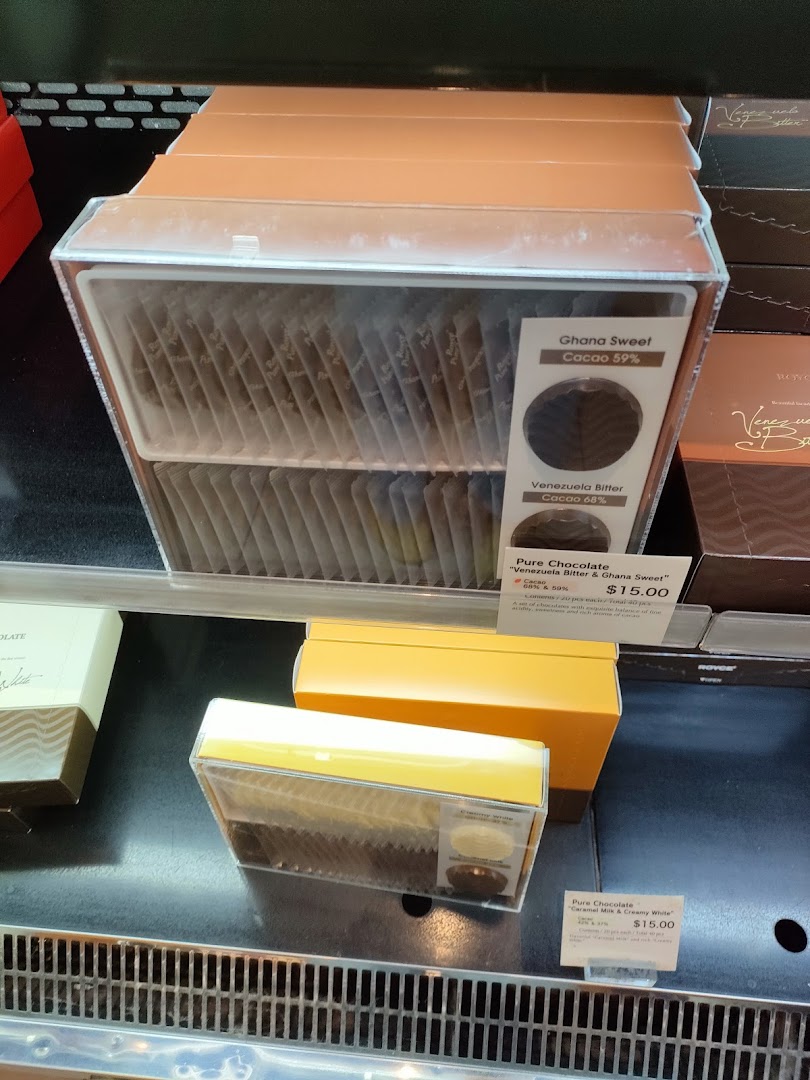 Assorted Royce Pure Chocolate varieties displayed in clear packaging with price tags.
