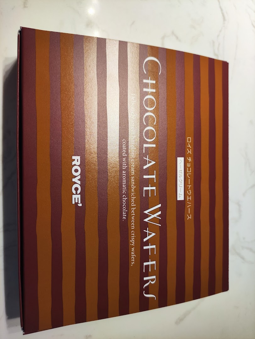 A box of Royce' Chocolate Wafers, featuring a striped design and product details.