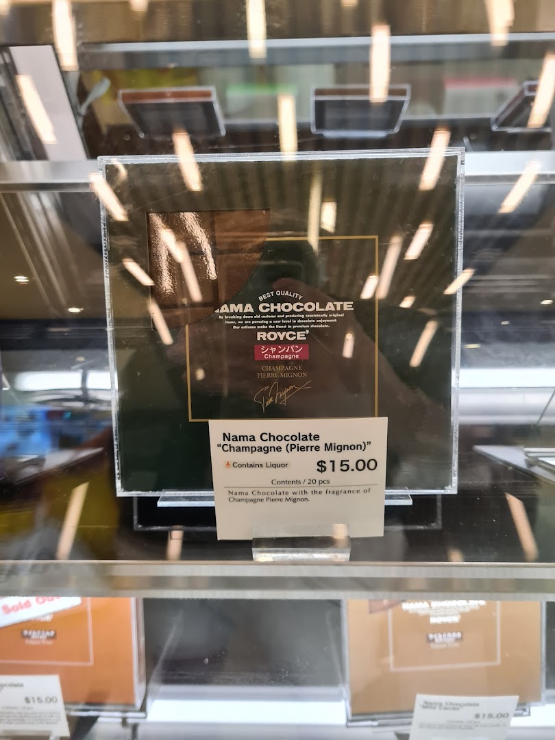 A box of Royce' Nama Chocolate 'Champagne (Pierre Mignon)' with its price tag in a display case.