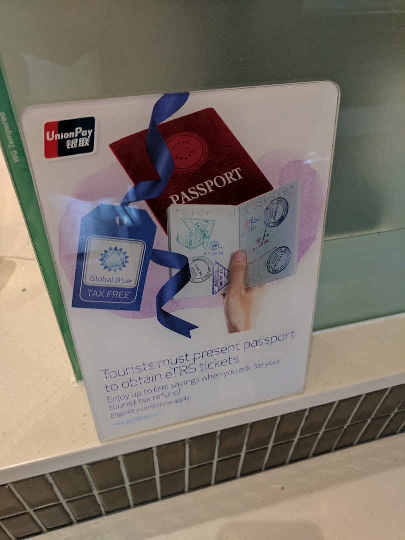 A sign informing tourists about tax refunds and eTRS tickets, featuring a passport and Global Blue logo.