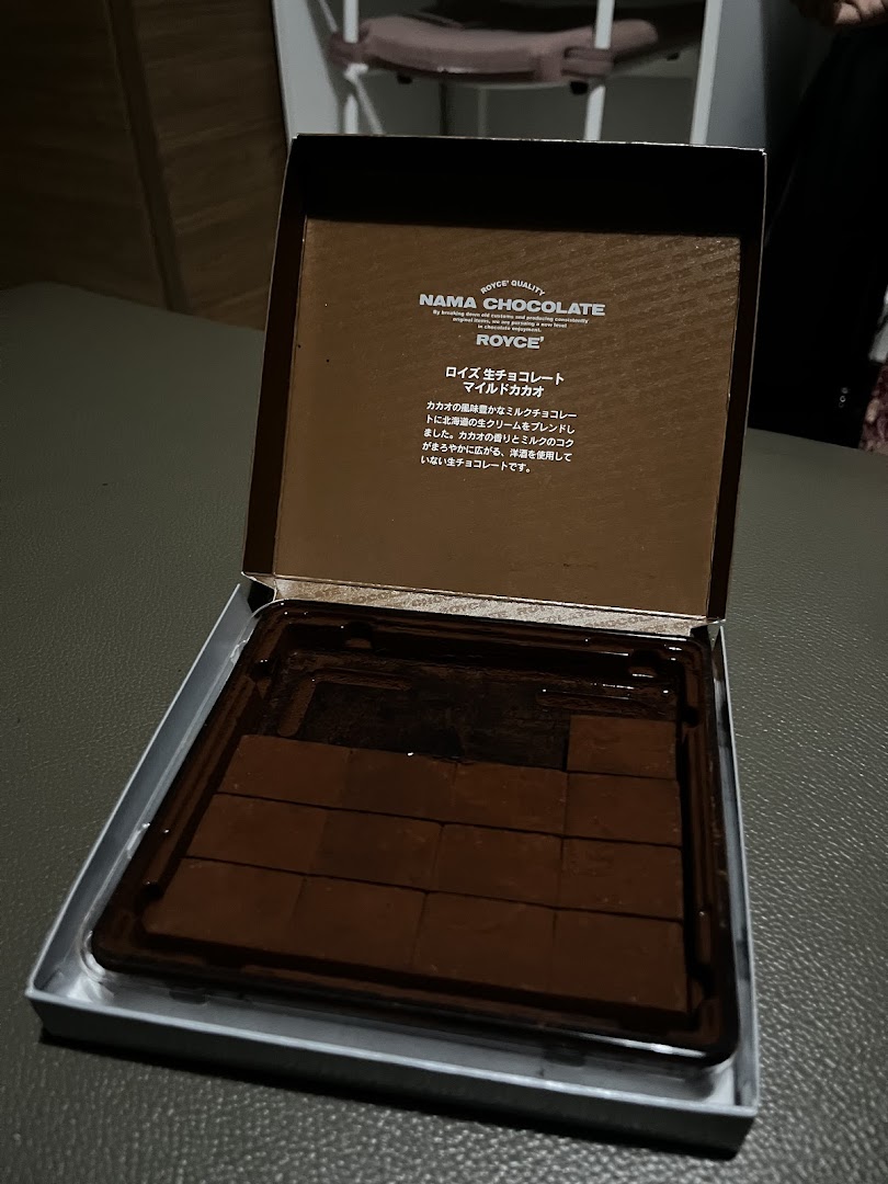 An open box of Royce Nama Chocolate, revealing rich, dark chocolate pieces inside.