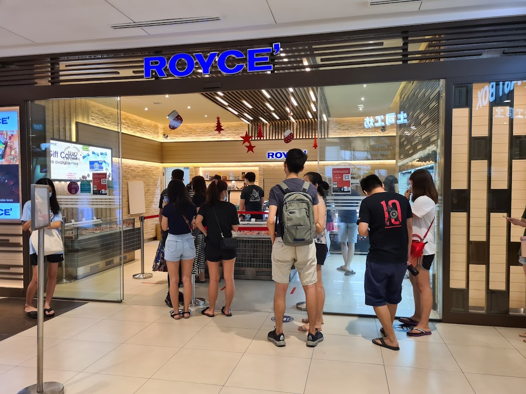People queue outside the Royce chocolate shop, showcasing its inviting entrance.