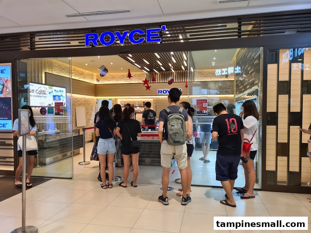 People queue outside the Royce chocolate shop, showcasing its inviting entrance.