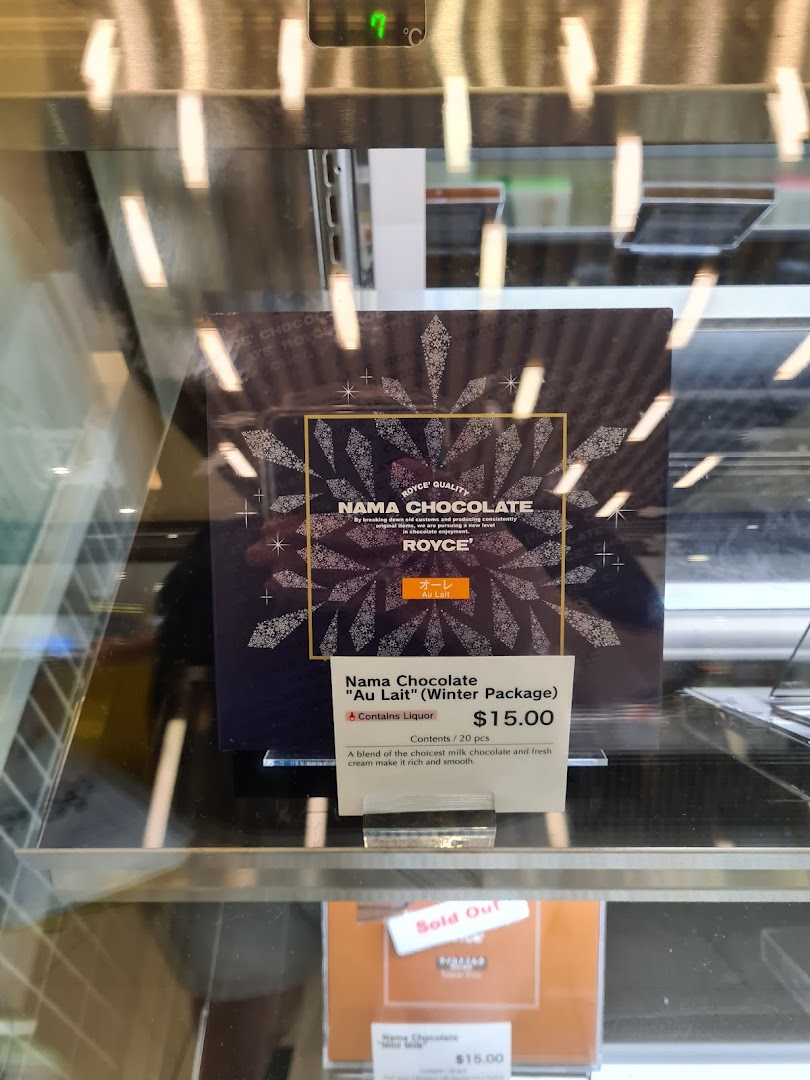 A display sign for Royce's Nama Chocolate 'Au Lait' (Winter Package) with price and description.