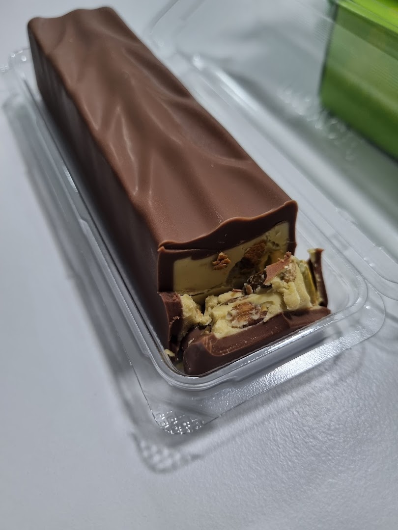 A partially eaten chocolate bar with a creamy, nutty filling, presented in clear plastic packaging.