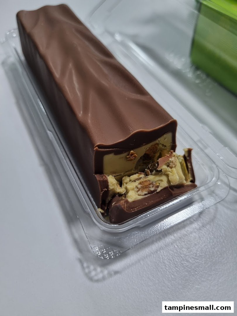 A partially eaten chocolate bar with a creamy, nutty filling, presented in clear plastic packaging.