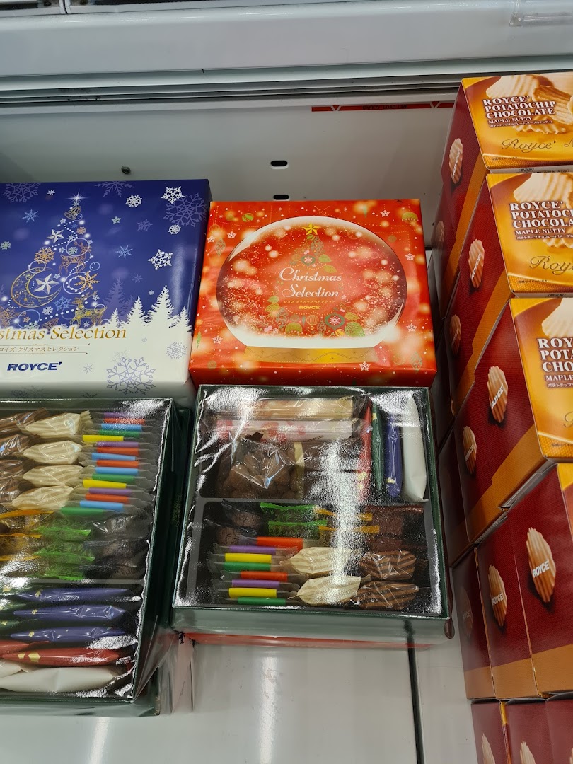 Various Royce chocolate products, including Christmas selection boxes and potato chip chocolates, displayed in a retail setting.