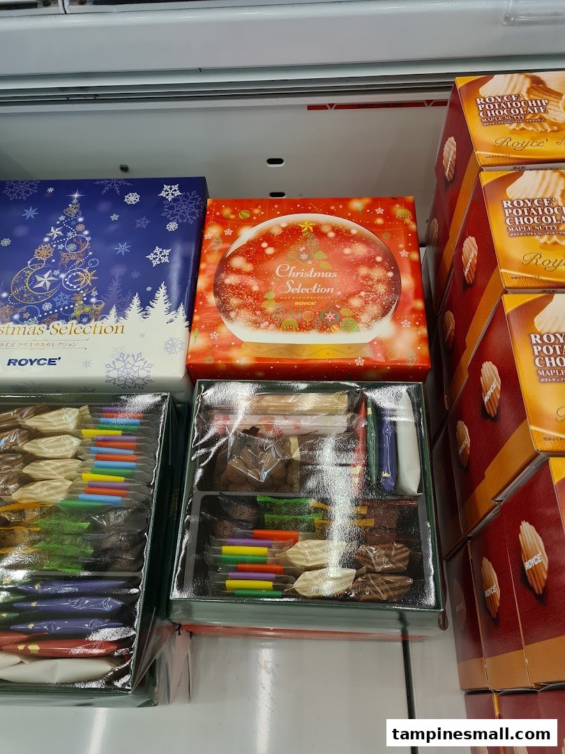 Various Royce chocolate products, including Christmas selection boxes and potato chip chocolates, displayed in a retail setting.