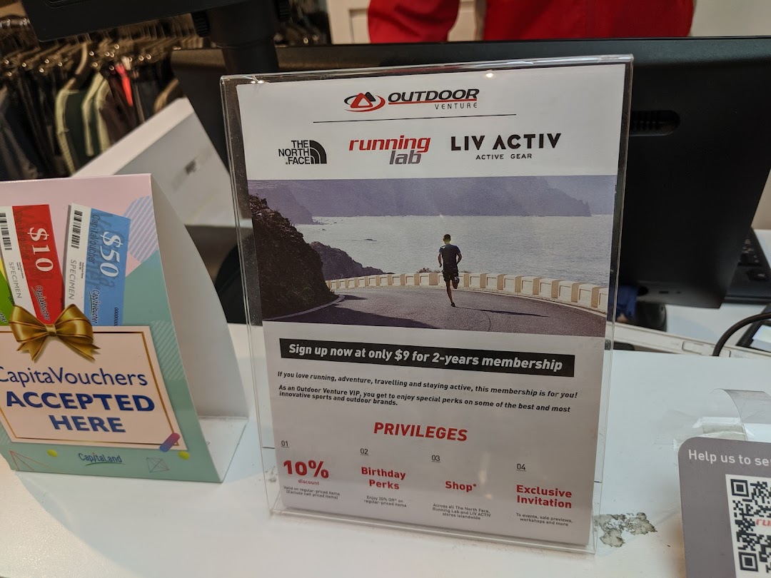 An in-store display at Running Lab Tampines showing membership benefits and accepted CapitaVouchers.