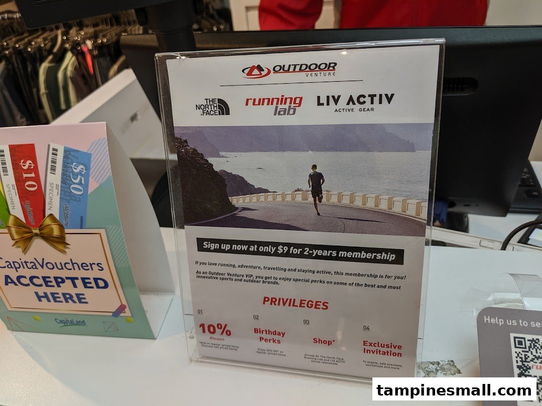 An in-store display at Running Lab Tampines showing membership benefits and accepted CapitaVouchers.