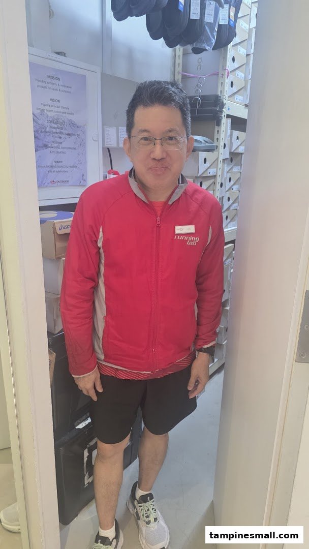 A staff member in a Running Lab jacket stands inside the store, surrounded by shoe boxes and merchandise.