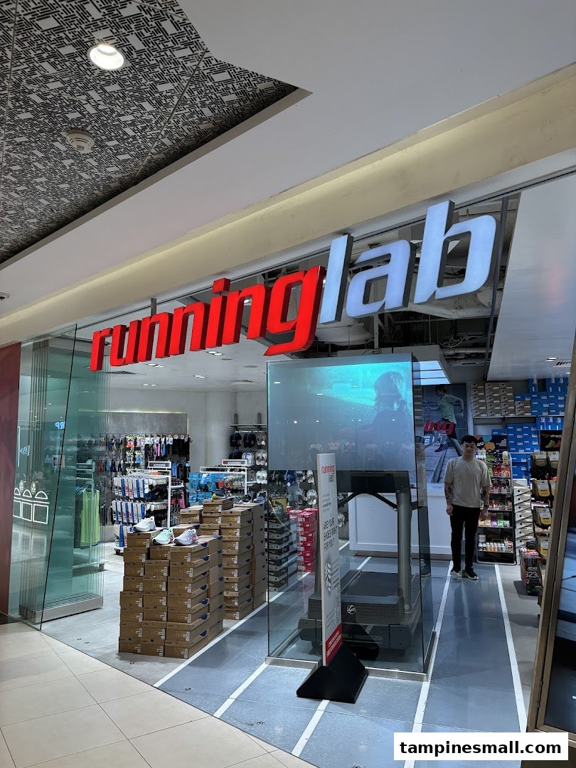 The storefront of Running Lab Tampines, showcasing its entrance, signage, and interior with shoes and a treadmill.