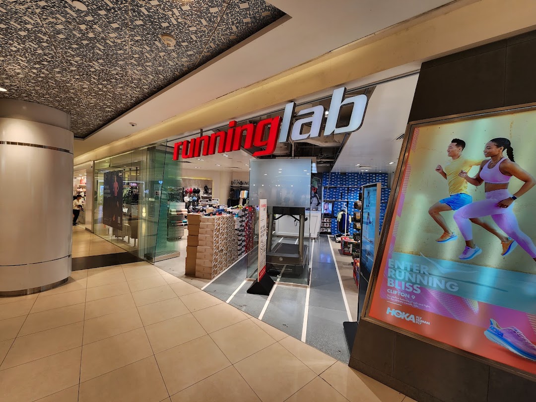 The storefront of Running Lab Tampines, featuring its logo and a large Hoka running shoe advertisement.