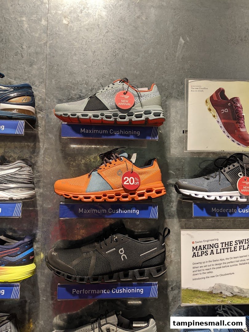 A wall display showcasing various running shoes with features like maximum cushioning and new arrivals.