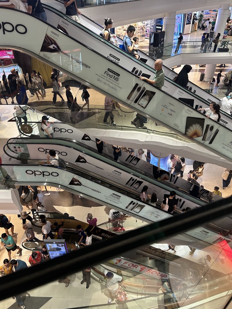 Dynamic view of multiple escalators in a bustling shopping mall, featuring large OPPO phone advertisements.