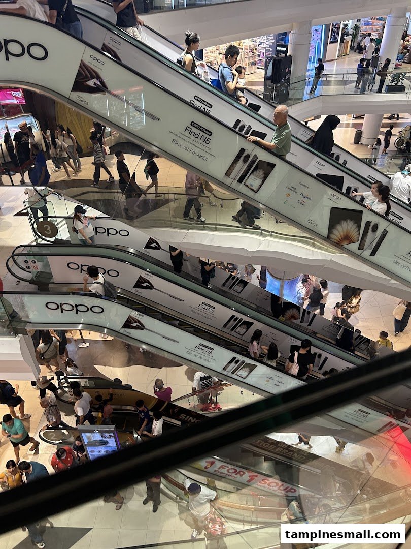 Dynamic view of multiple escalators in a bustling shopping mall, featuring large OPPO phone advertisements.