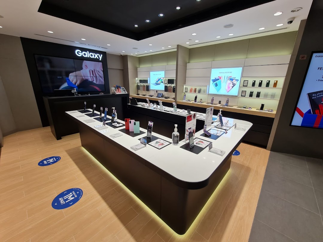 Interior view of a modern Samsung Experience Store showcasing Galaxy phones, accessories, and interactive displays.