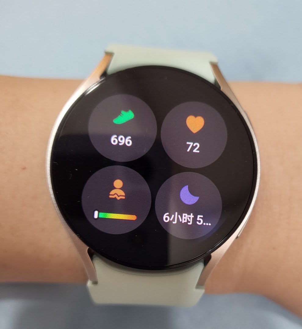 A close-up of a Samsung smartwatch on a wrist, displaying health and activity tracking data.