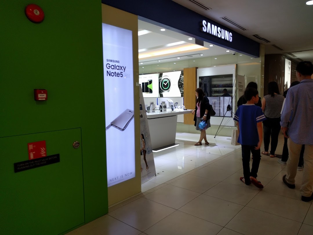 The brightly lit entrance of a Samsung Experience Store, showcasing products and inviting visitors inside.