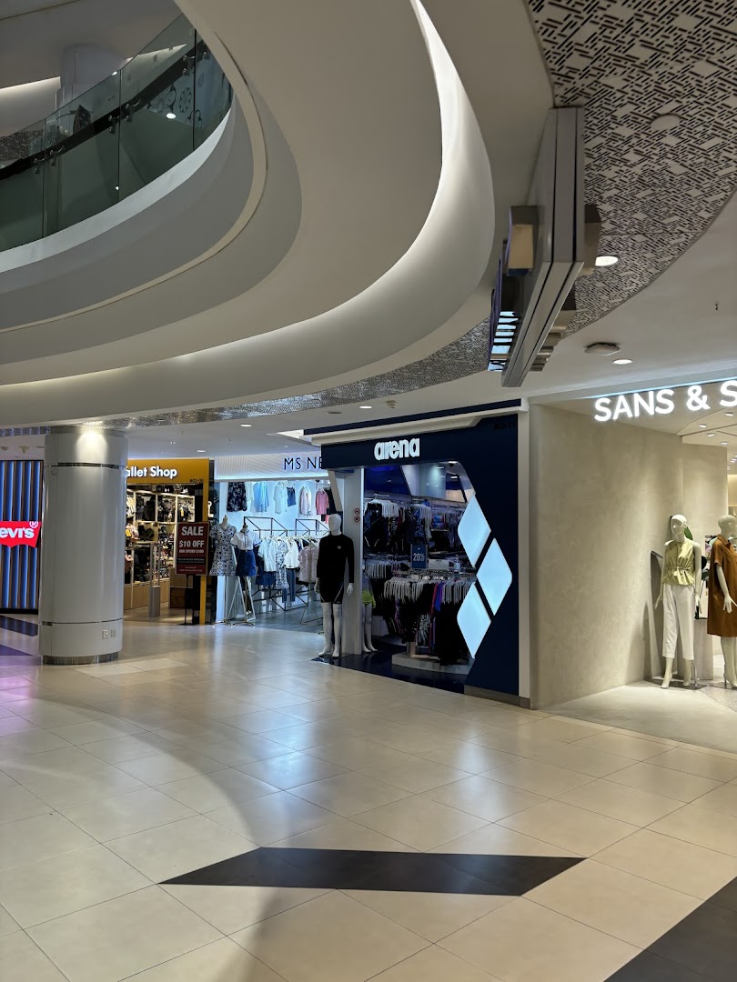 View of SANS SANS shop entrance with mannequins and other retail stores in a modern mall setting.