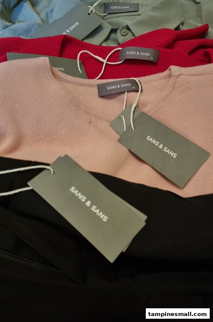 Close-up of various colored clothing items with 'SANS & SANS' brand tags.