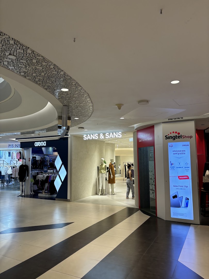 The entrance of SANS & SANS fashion boutique with mannequins and a nearby Singtel kiosk.
