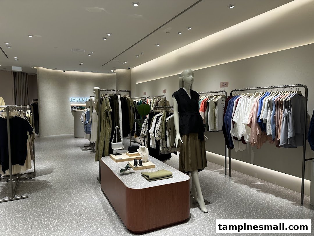 An interior view of SANS SANS, showcasing stylish clothing on racks and mannequins in a modern setting.