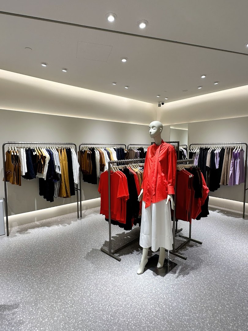 Interior view of SANS SANS clothing store featuring apparel racks and a mannequin.